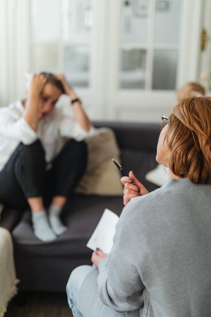 A therapist comforts a worried client during a counseling session.